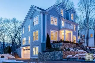 A large house with a lot of windows is lit up at night.