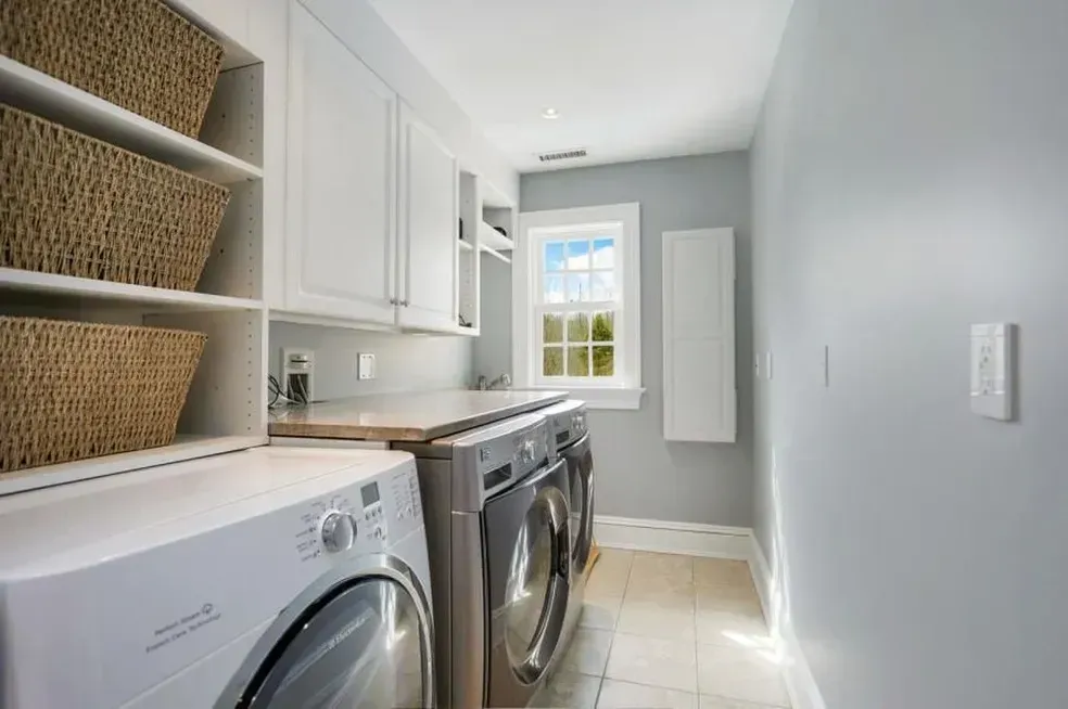 A laundry room with a washer and dryer and wicker baskets.