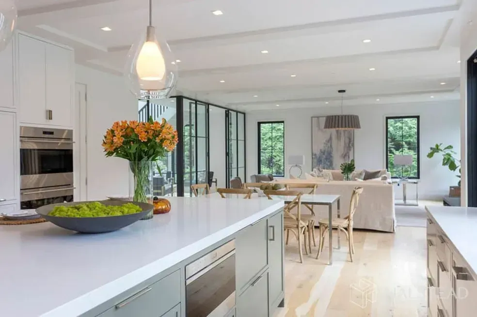 A kitchen with a large island and a vase of flowers on the counter.
