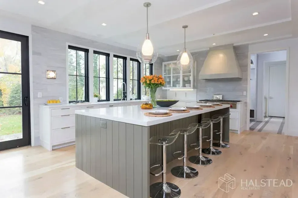 A kitchen with a large island and stools.