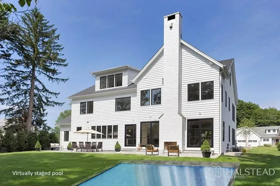 A large white house with a swimming pool in the backyard