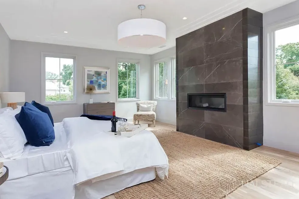 There is a fireplace in the middle of the bedroom.