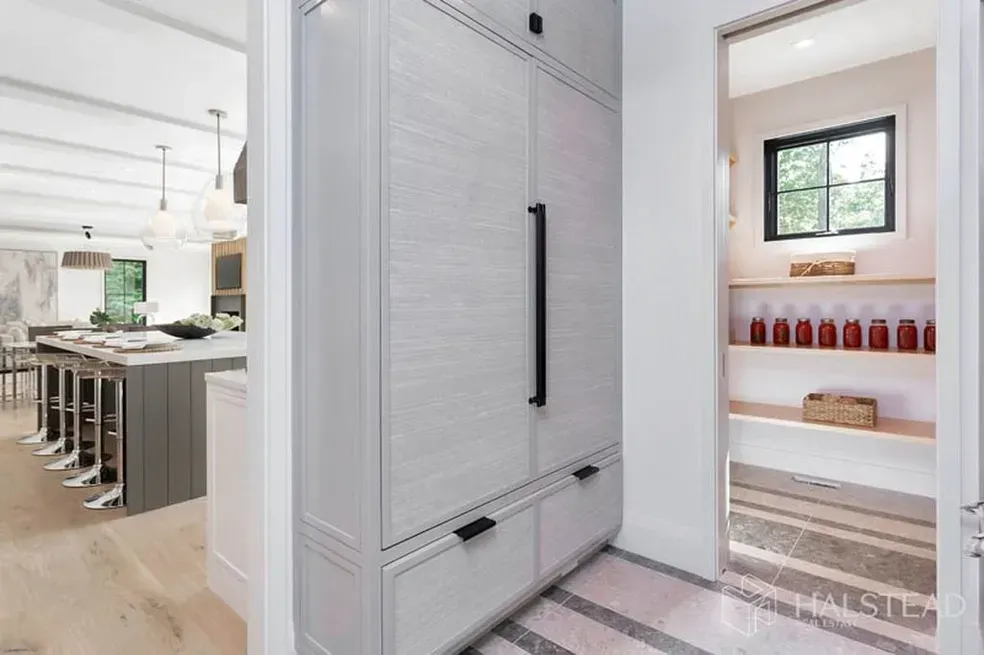 A kitchen with a large refrigerator and a pantry.
