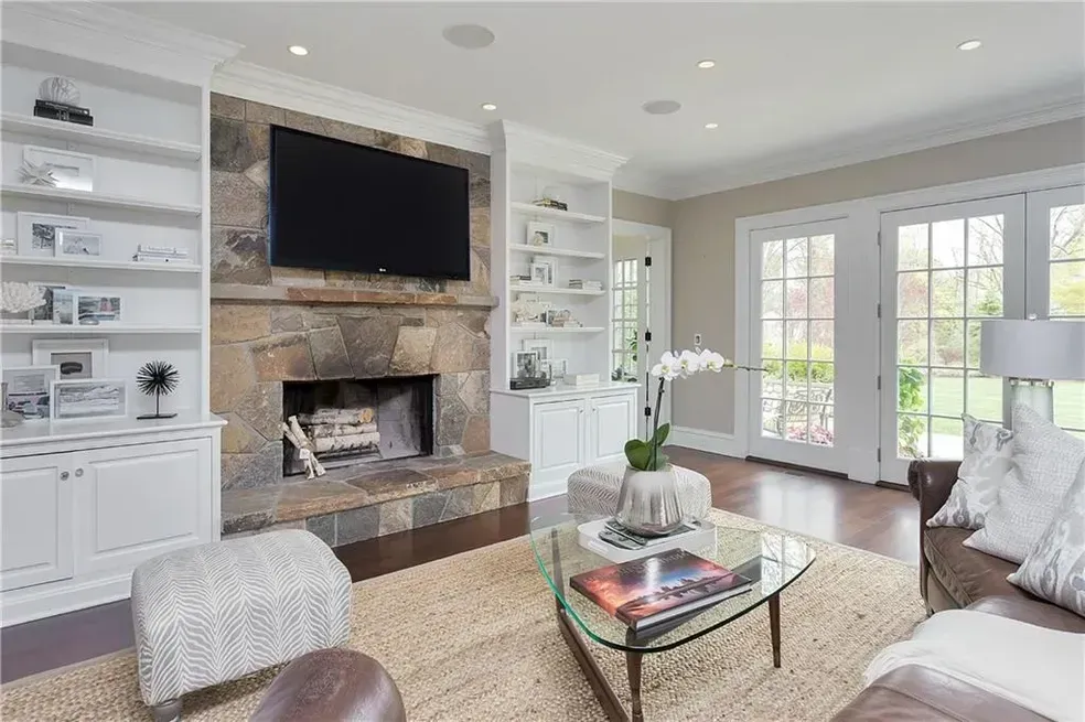 A living room with a fireplace and a flat screen tv.