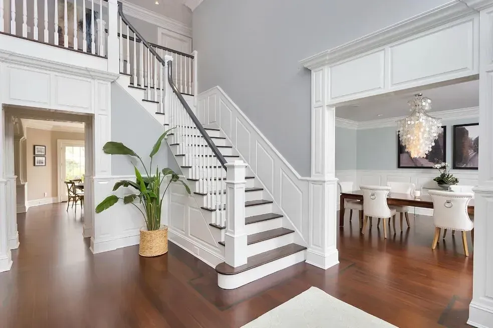 There is a staircase in the middle of the room leading up to the second floor.