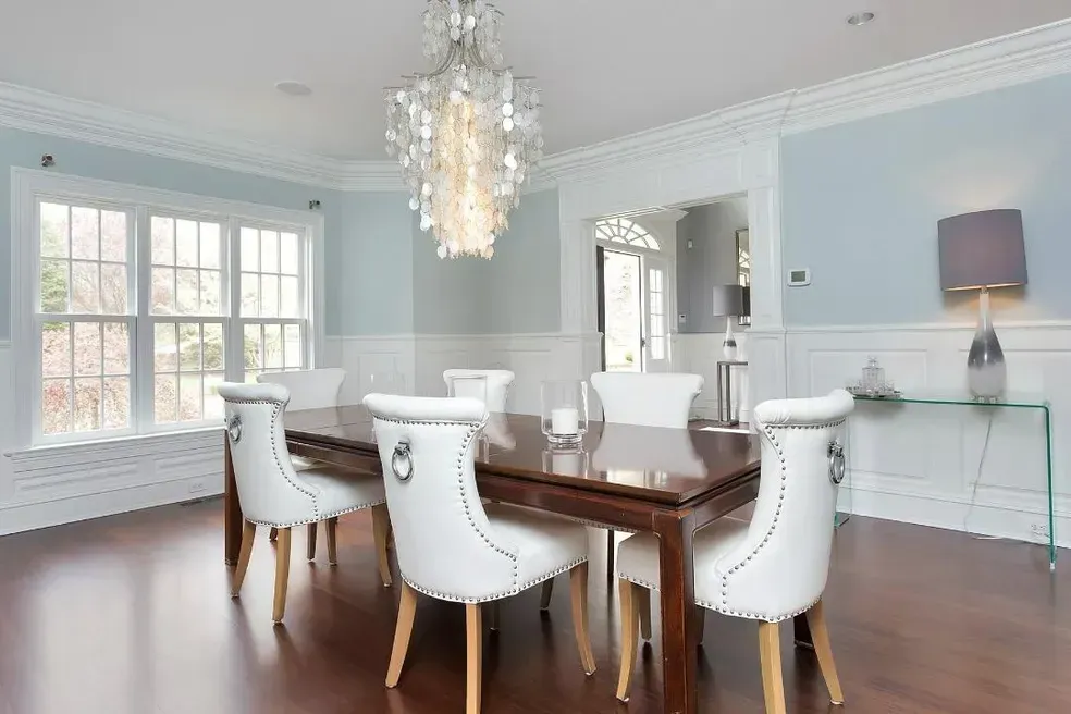 A dining room with a table and chairs and a chandelier.