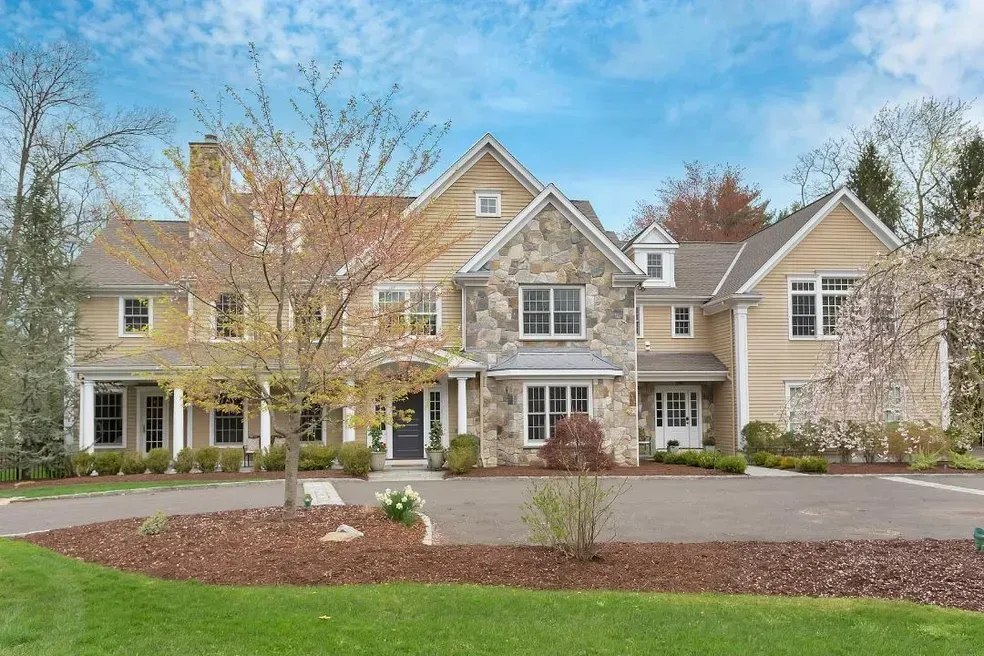 A large house with a lot of windows is sitting on top of a lush green hillside.