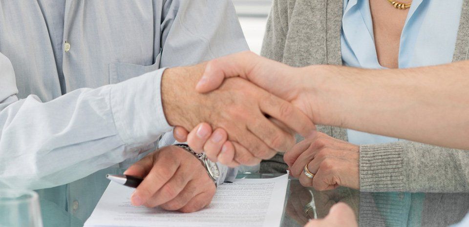 Senior Happy Couple Shaking Hand With Financial Advisor