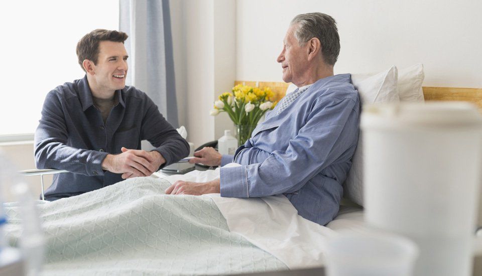 Caucasian son visiting father in hospital