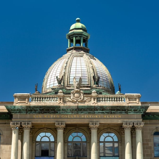 Beaux-Arts style dome of the San Mateo County History Museum in Redwood City, California, viewed from the front under a clear blue sky