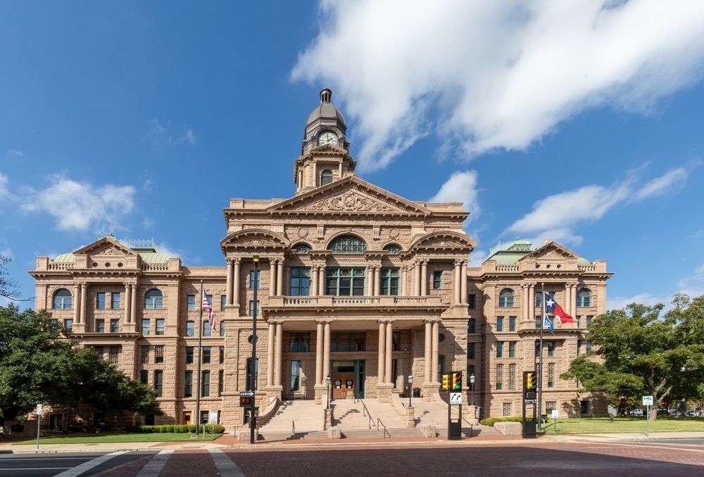 The Tarrant County Courthouse in Fort Worth, Texas, features its historic pink granite facade and central clock tower.