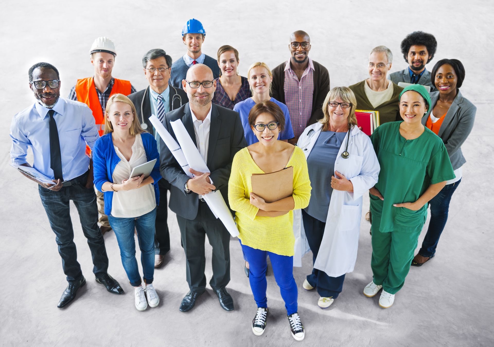 A large group of people of different safety sensitive positions are posing for a picture.