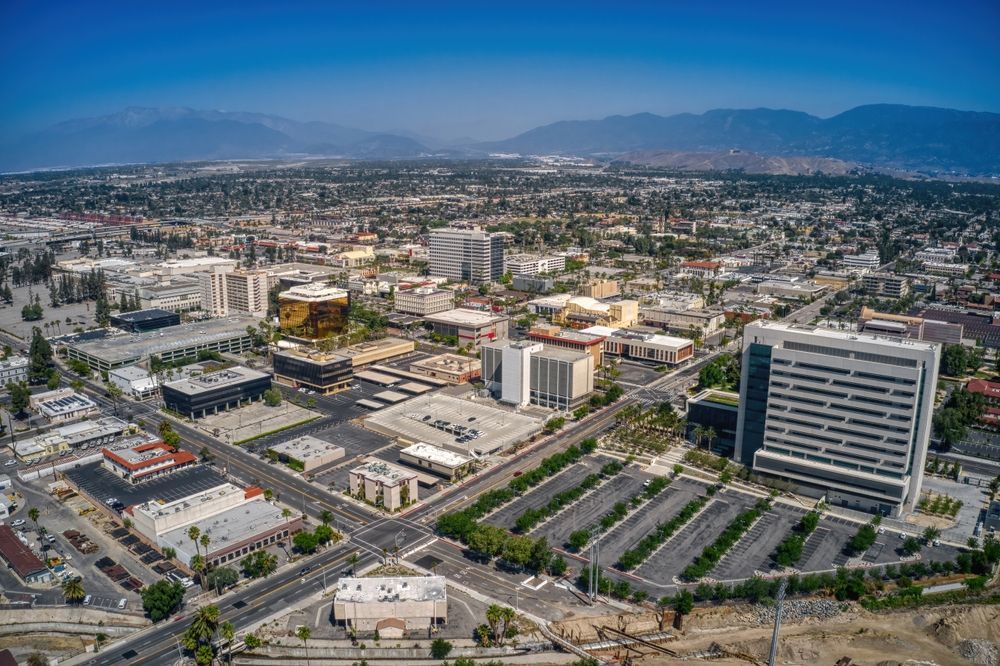 An aerial view of a city with mountains in the background. San Bernadino background screening data supplier.