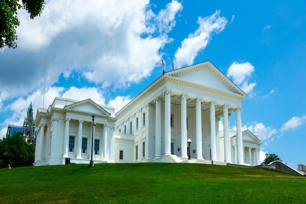 A large white building with columns and a blue sky in the background