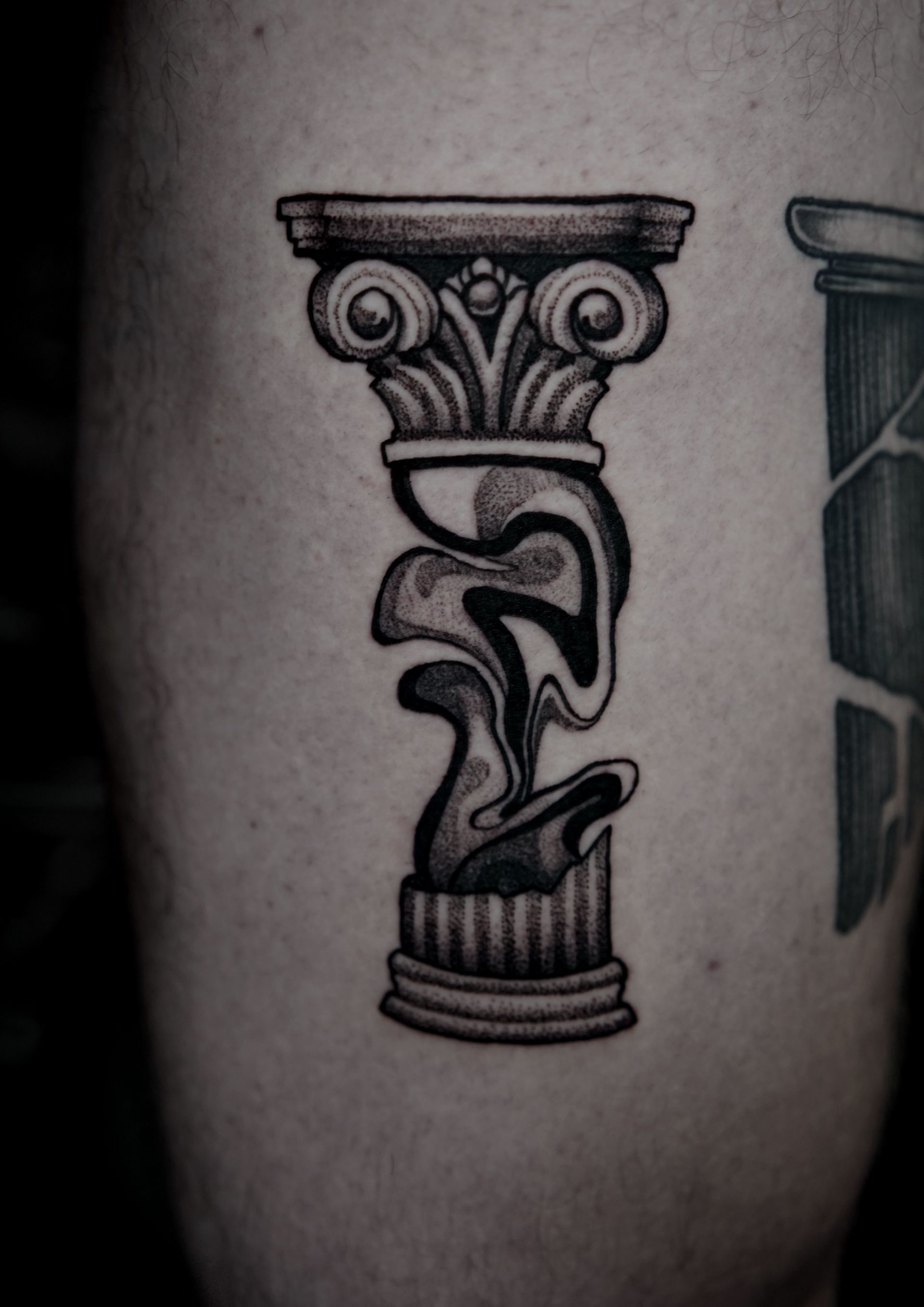 Tattoo of an ornate classical column with a distorted, melting middle section, on human skin.
