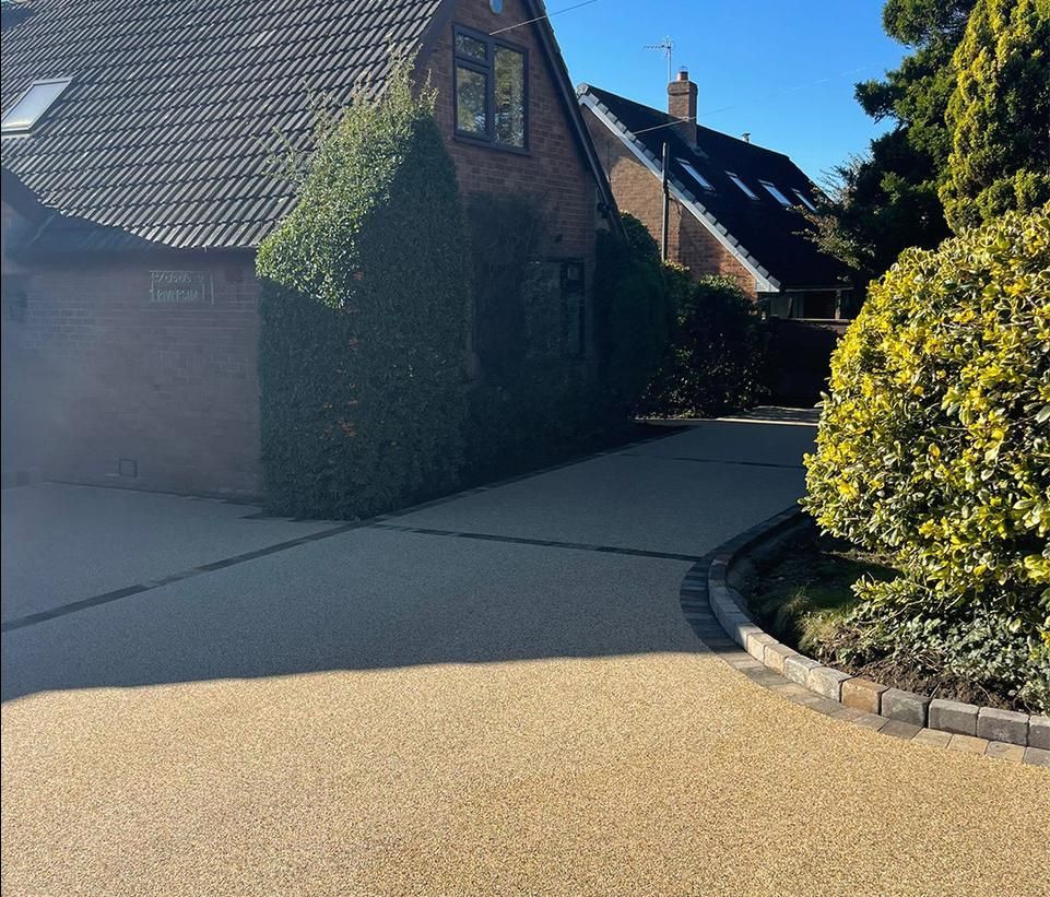 A brick house with a driveway leading to it