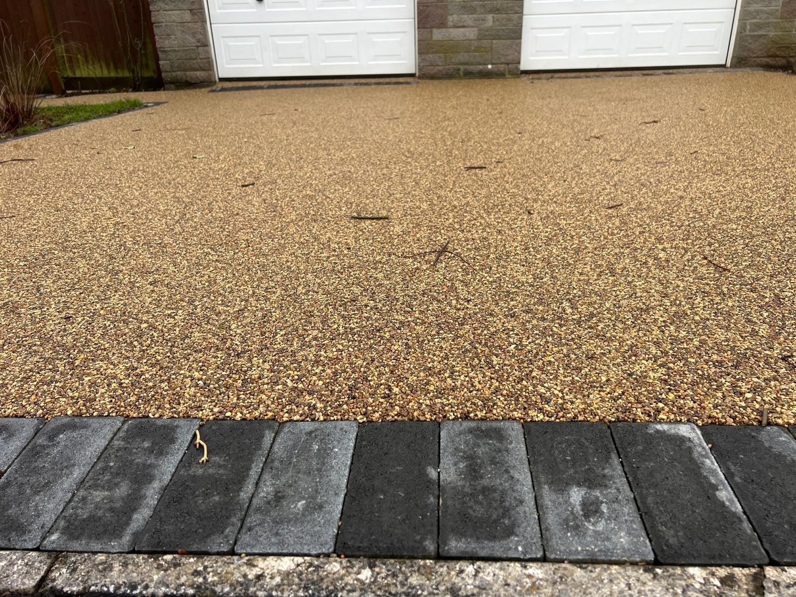 A close up of a driveway with a garage in the background.