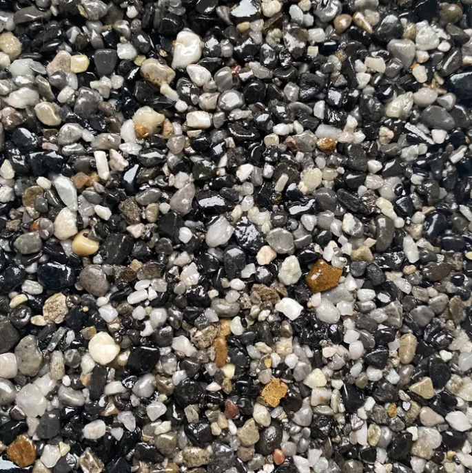 Close-up of a mix of small, polished pebbles in various shades of gray, black, and white.