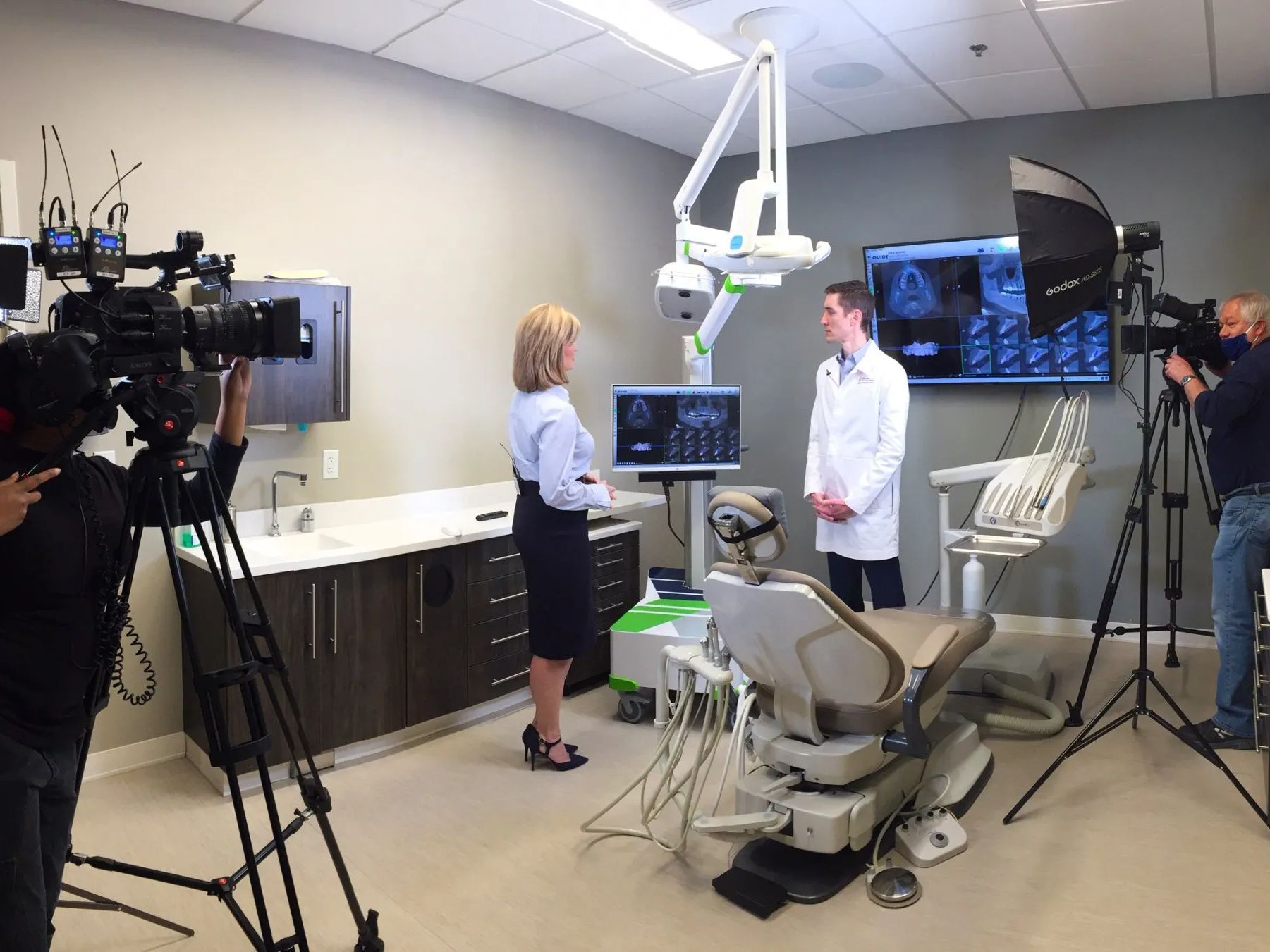 A woman is talking to a man in a dental office