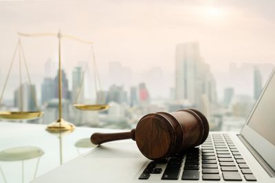 Law Defense - Wooden Gavel on Laptop Keyboard With Scales of Justice in Belvidere, NJ