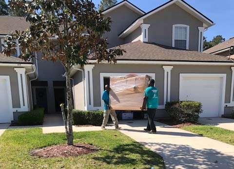 Move Houses — Men's moving the table inside the house  in Jacksonville,