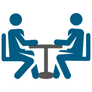 two people are sitting at a table having a conversation
