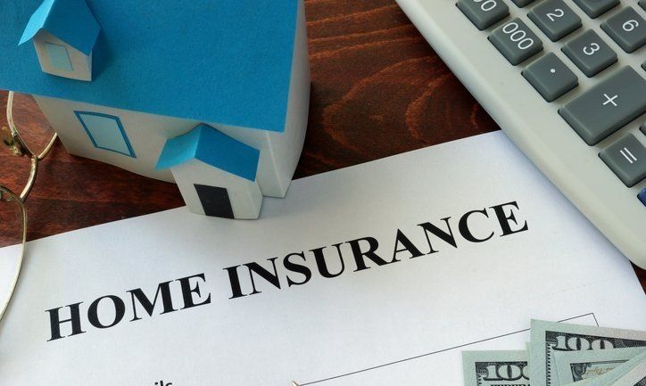 a house is sitting on top of a home insurance form