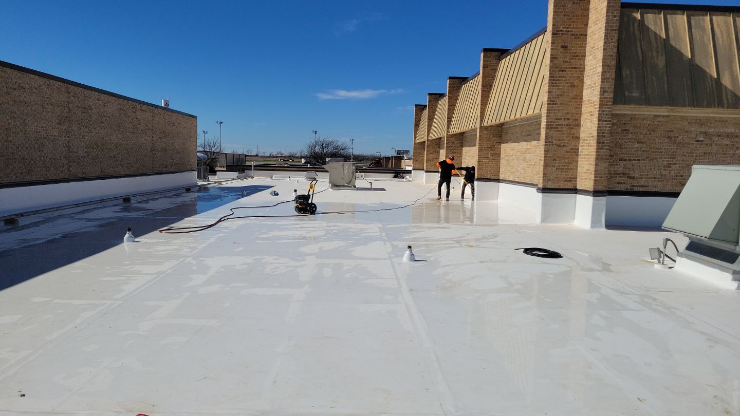 A large building is being demolished by a large excavator.