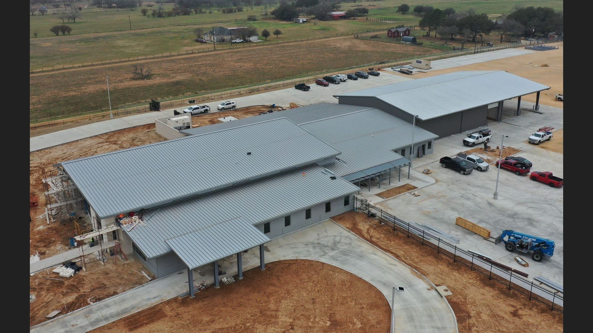 Two construction workers are standing in front of a building that is being demolished.