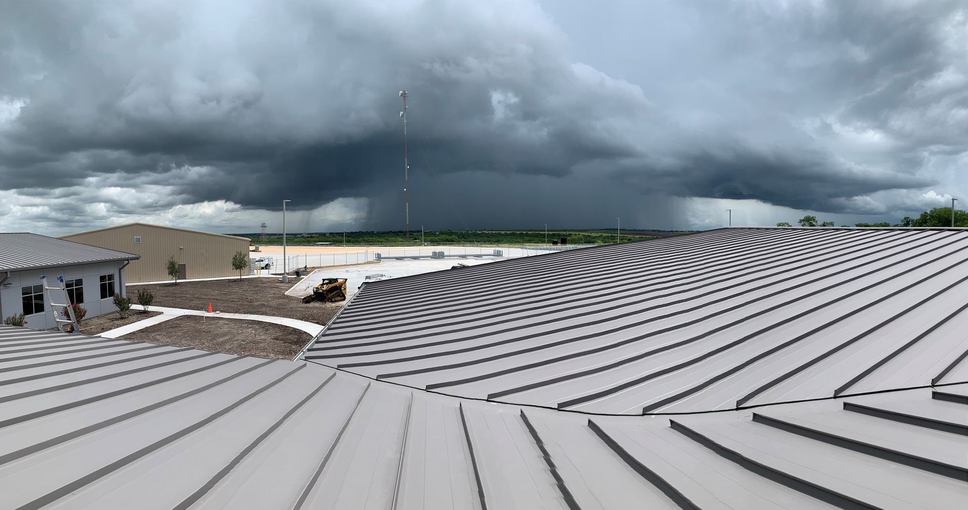 Two excavators are working on a building that is being demolished.