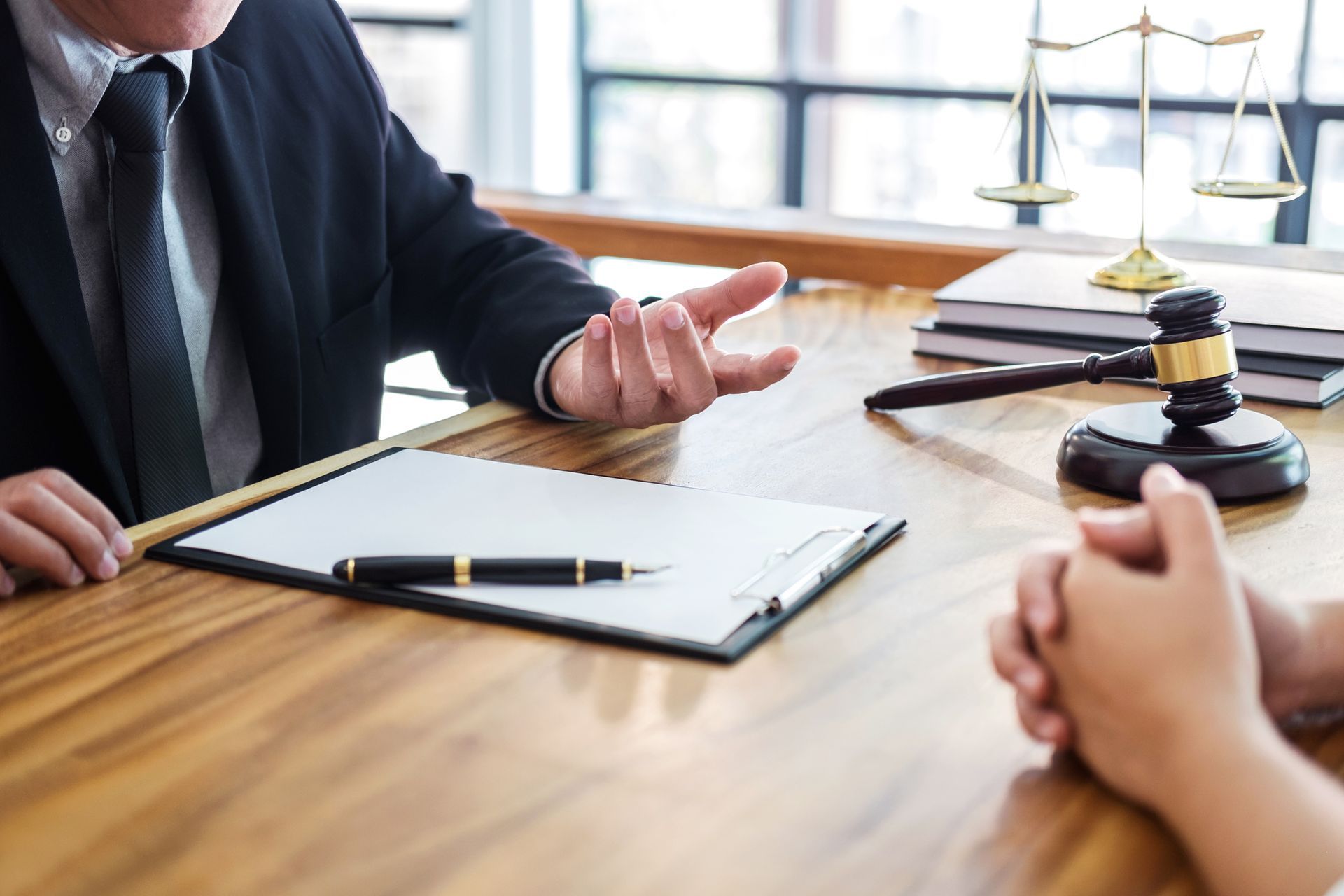 A man in a suit and tie is sitting at a table talking to a woman.