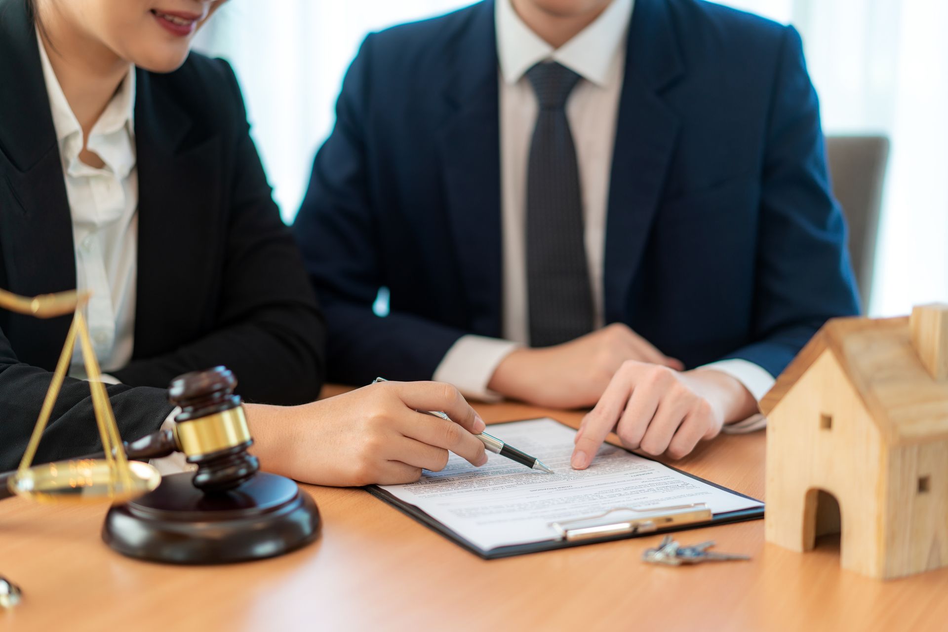 A man and a woman are sitting at a table looking at a piece of paper. A man and a woman are sitting at a table looking at a piece of paper.