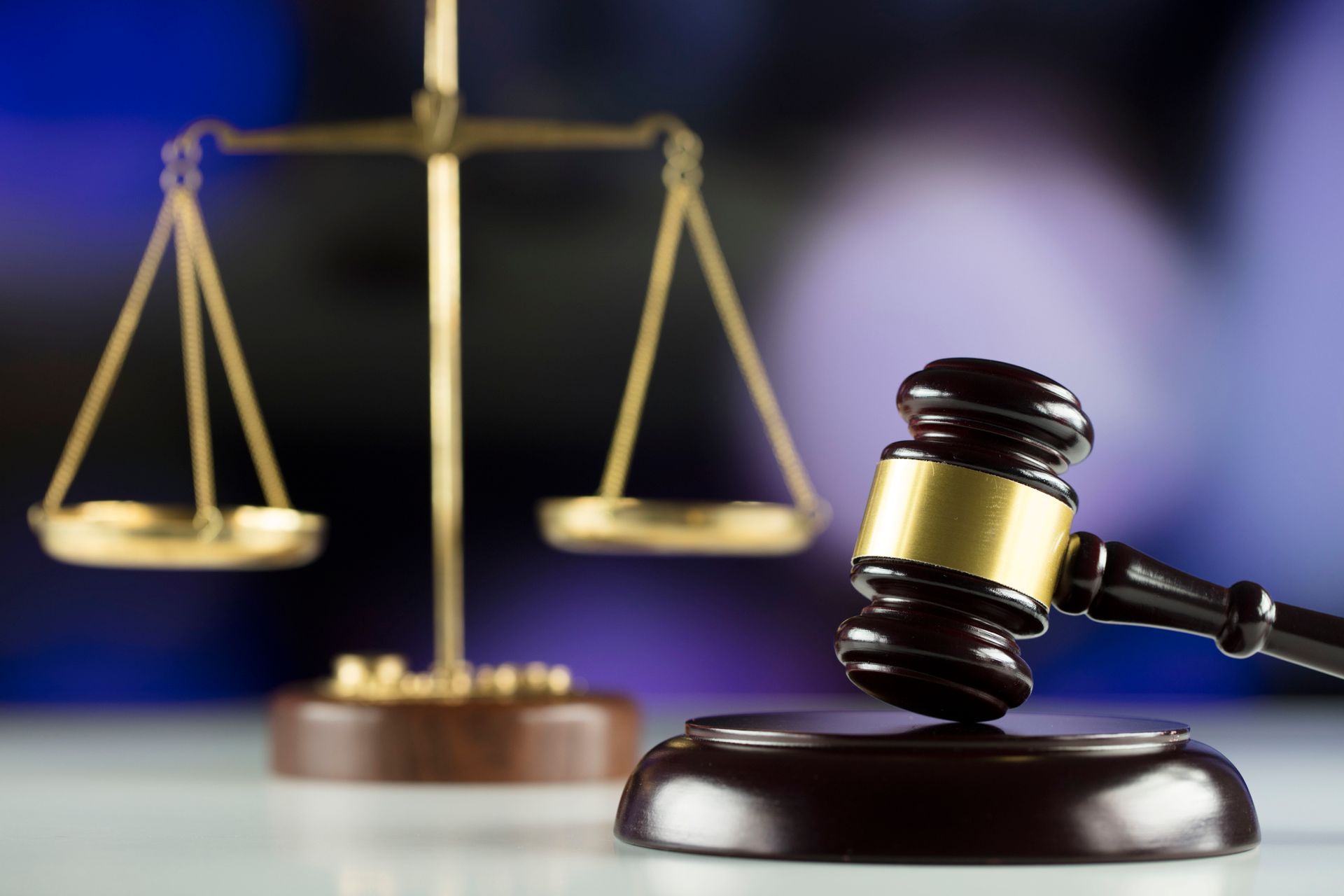 A judge 's gavel is sitting in front of a scale of justice.