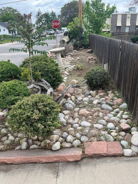 A stop sign is in the middle of a rock garden.