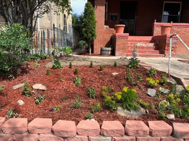 A brick house with a garden in front of it.