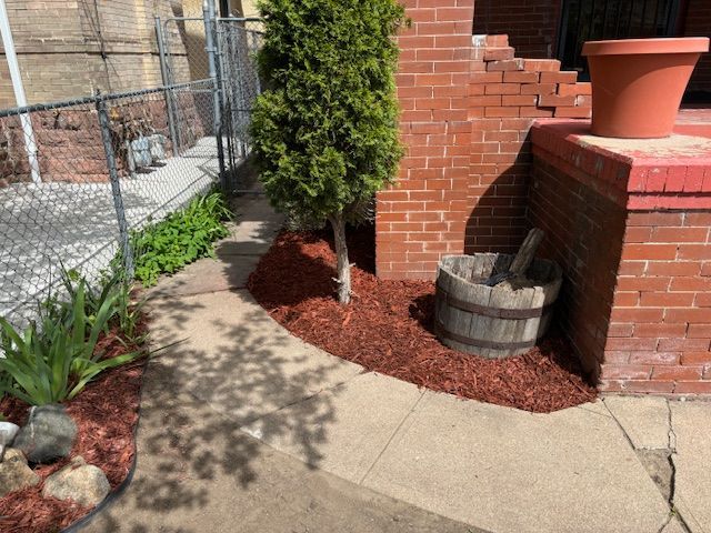 A wooden barrel is sitting on the sidewalk in front of a brick building.