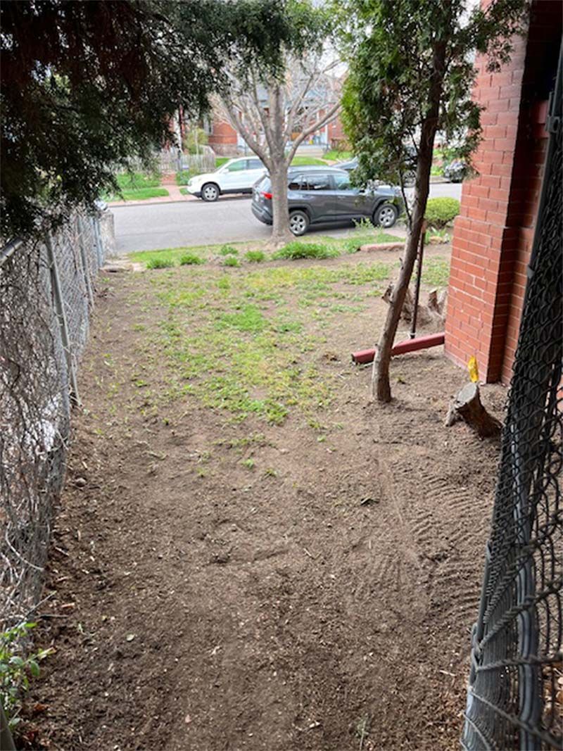 A fenced in yard with a car parked in the background.
