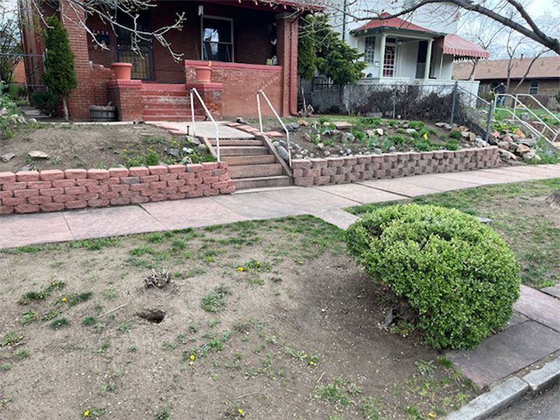 A brick house with stairs leading up to the front door.