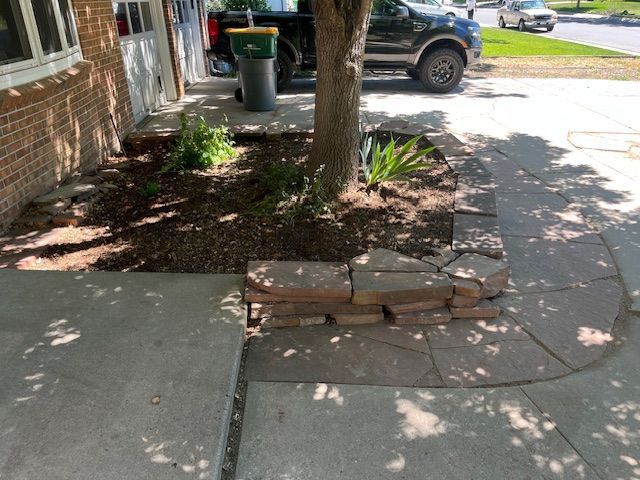 A truck is parked on the side of the road next to a tree.