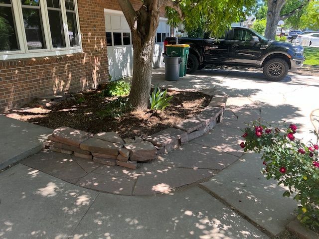 A black truck is parked in front of a brick house.