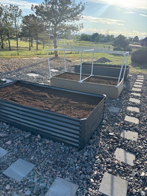 A couple of raised garden beds sitting on top of a pile of rocks.