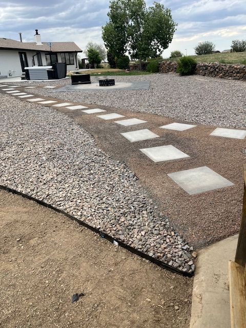 A stone walkway leading to a house with a house in the background