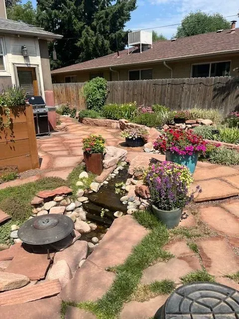 A concrete walkway leading to a lush green yard.