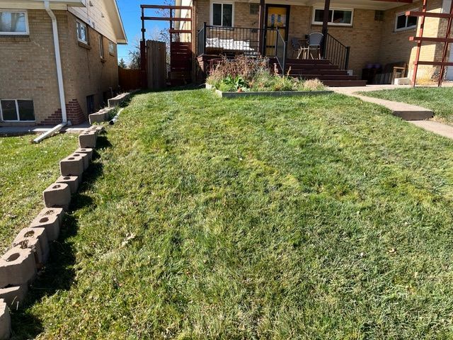 A house with a lush green lawn in front of it.