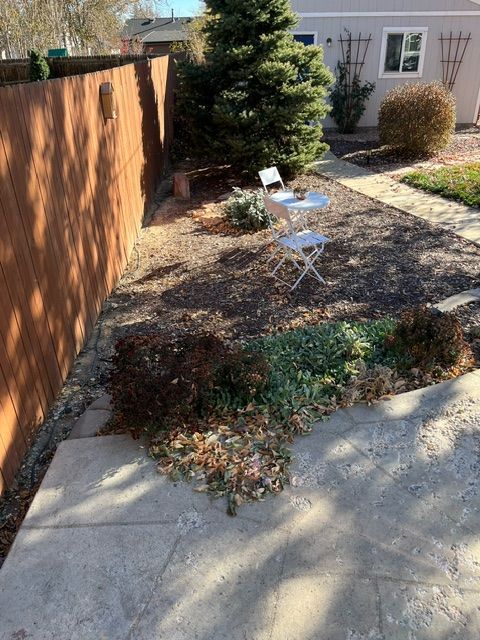 A backyard with a wooden fence and chairs