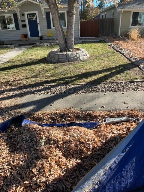 A pile of leaves and a shovel in front of a house