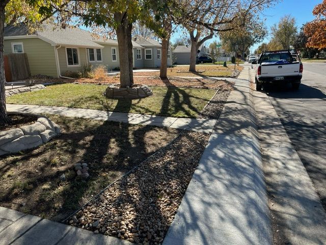 A white truck is parked on the side of the road in front of a house.