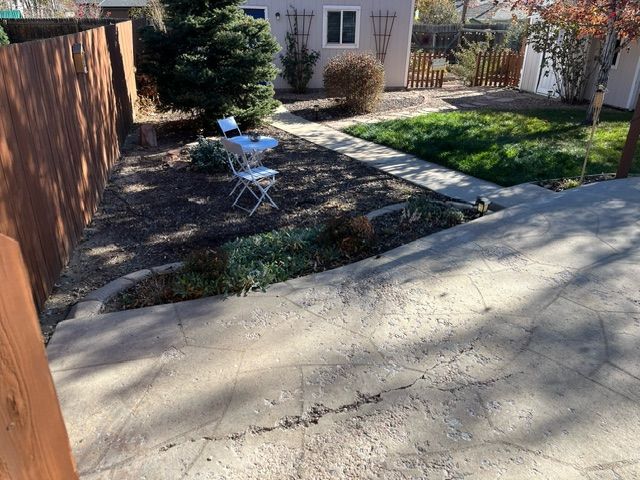 There is a table and chairs in the backyard of a house.