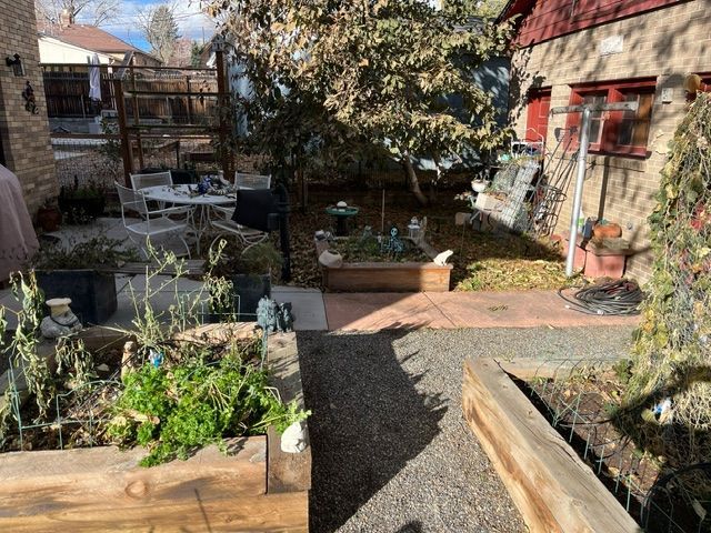 There is a table and chairs in the backyard of a house.