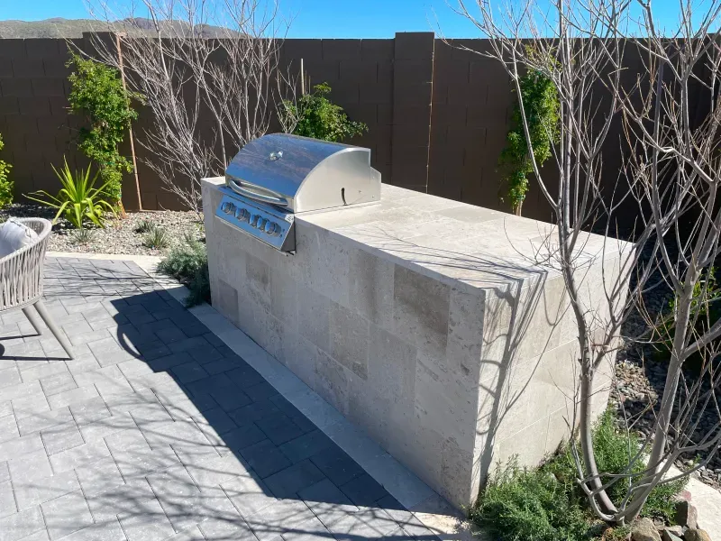 Outdoor stone grill station with stainless steel grill.